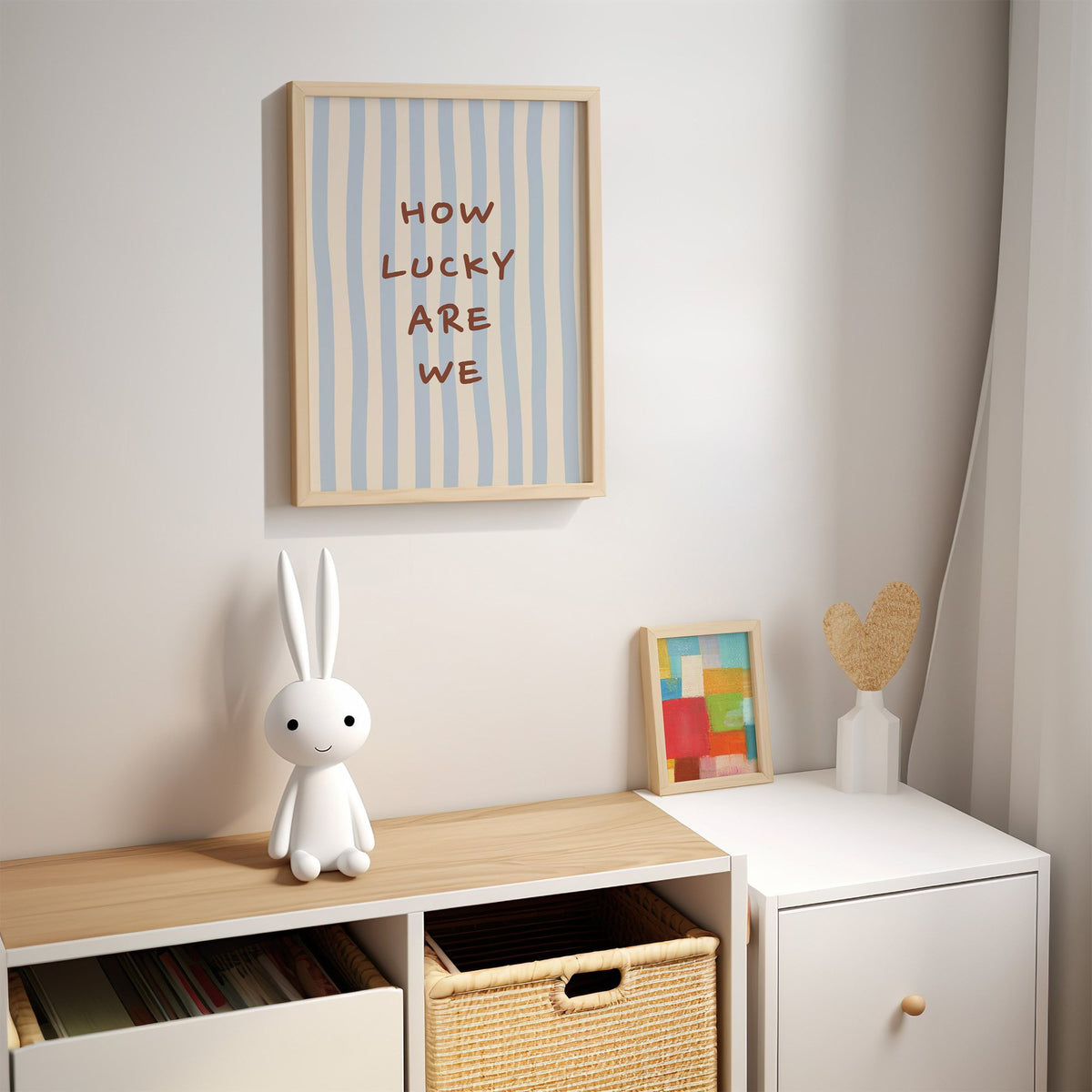 How lucky are we nursery print in an oak frame above a kids cubby shelf with a woven basket and bunny lamp