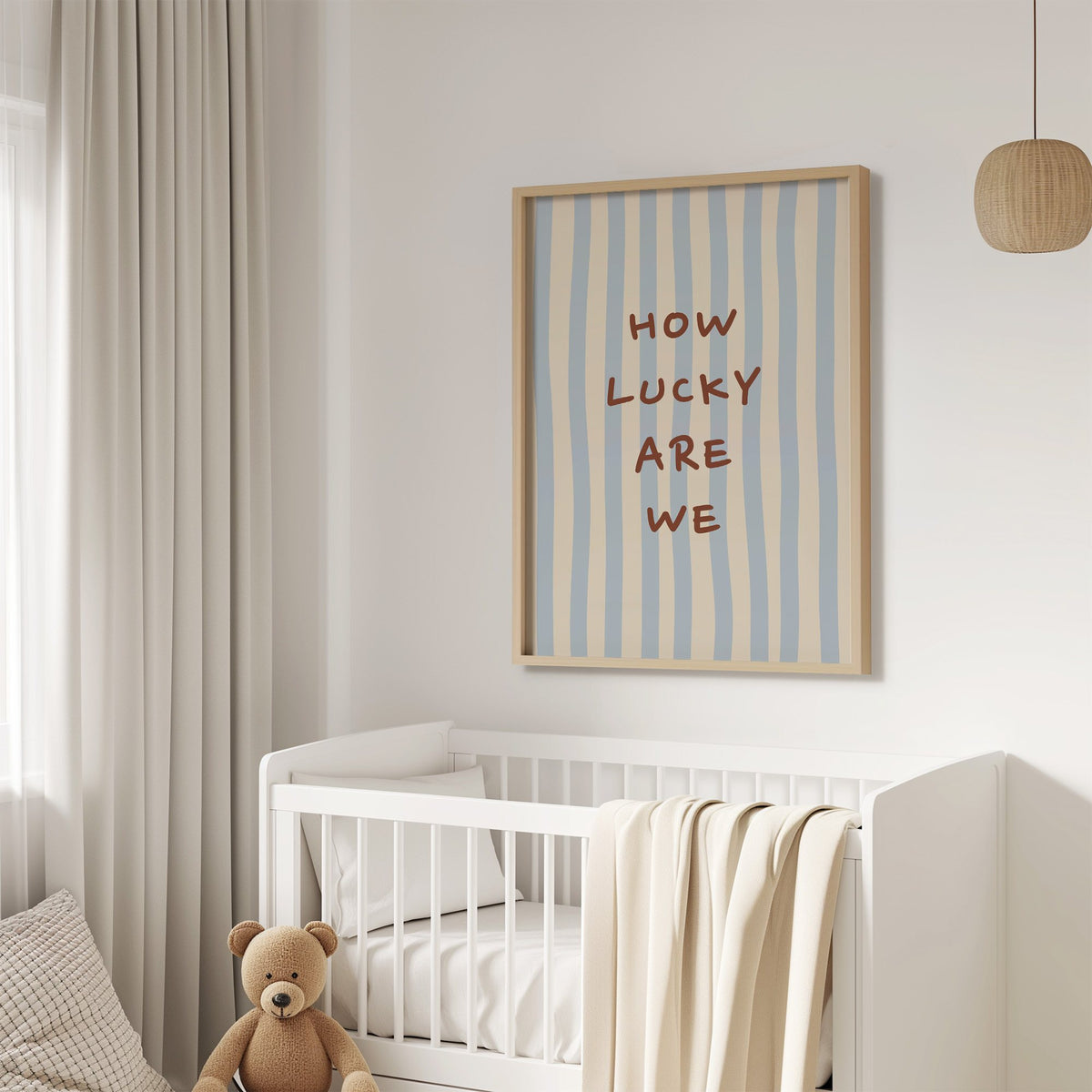 How lucky are we nursery print in an oak frame above a white crib with a teddy bear