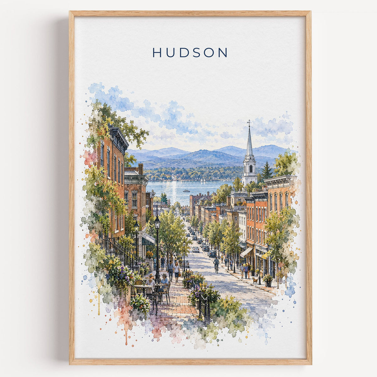 Hudson, New York watercolor print in a light oak frame on a plain white wall