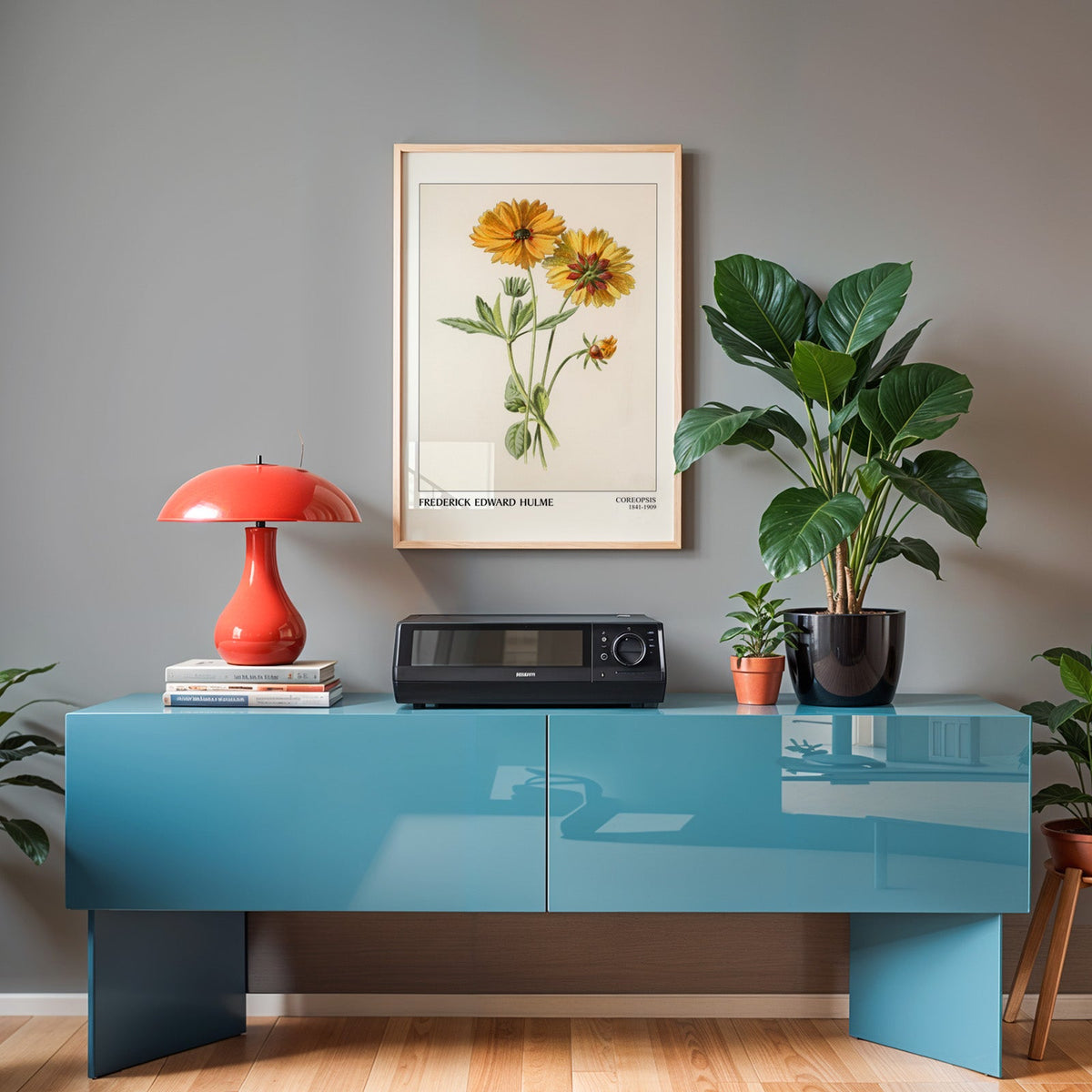 Coreopsis print in an oak frame above a teal sideboard with a red lamp