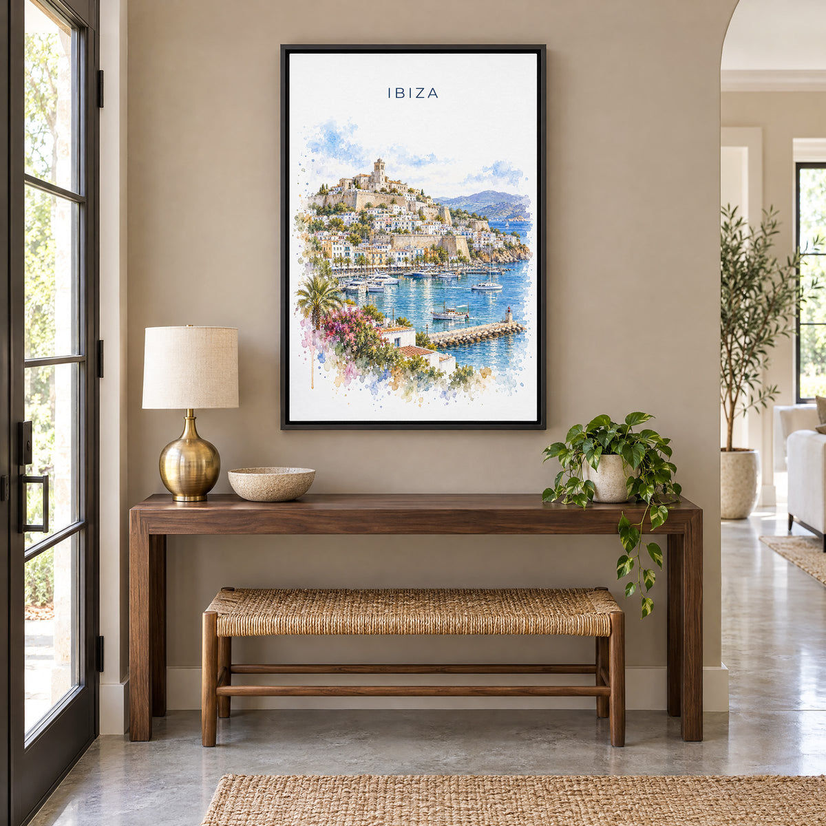 Ibiza watercolor print as a black floater canvas above a walnut console and woven bench in an entryway