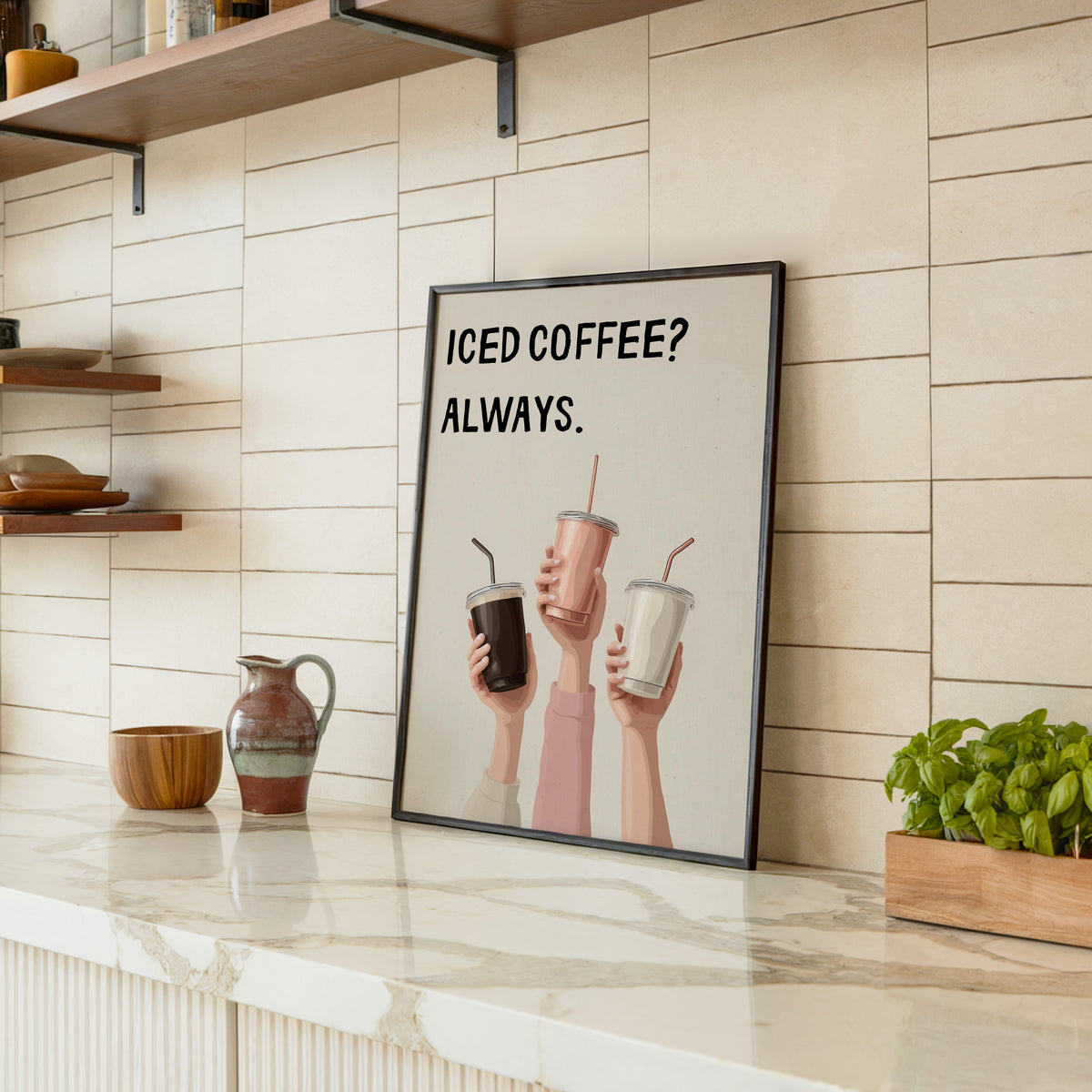 Iced Coffee Always print in a black frame leaning on a marble counter in a tiled kitchen