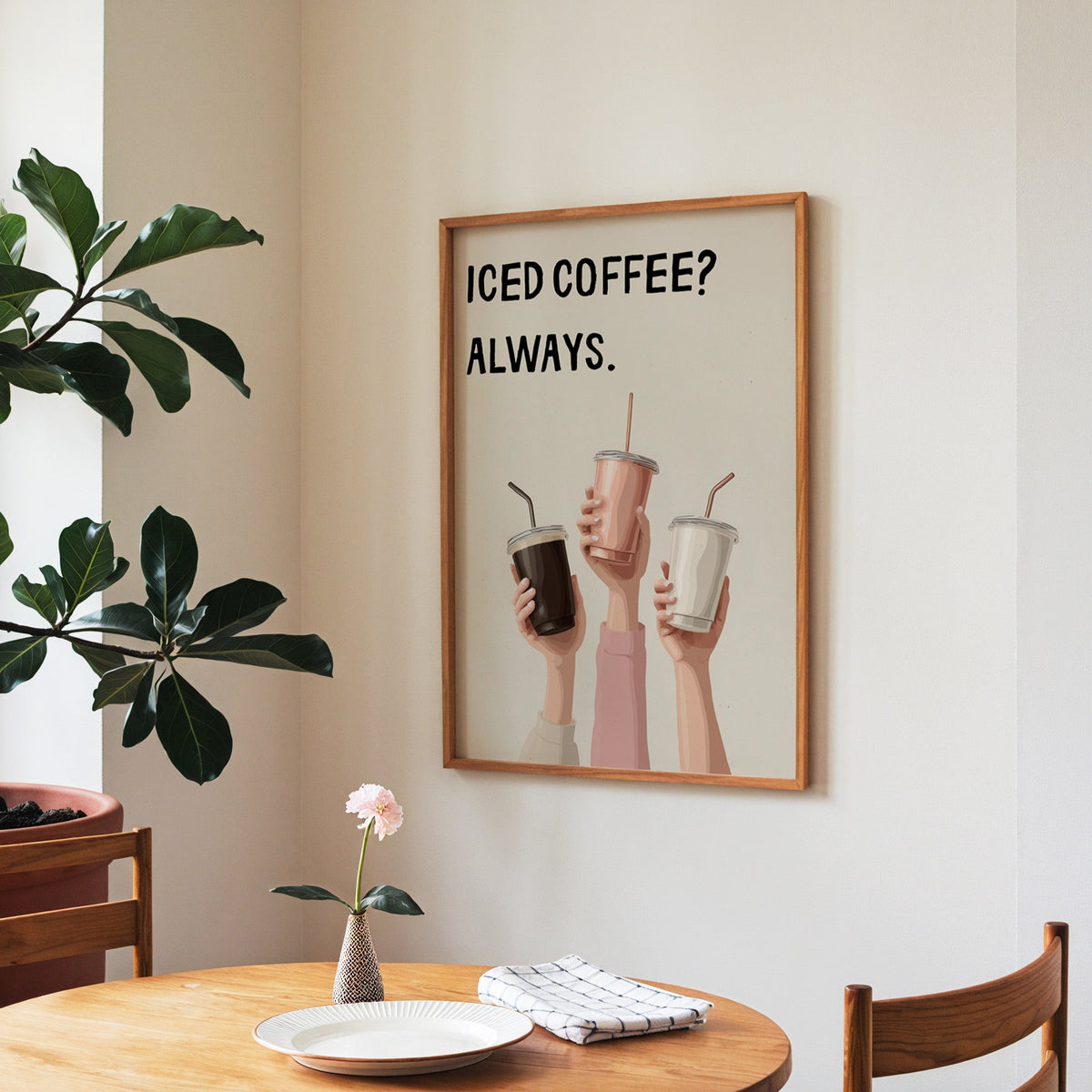 Iced Coffee Always print in a walnut frame above a round table beside a fiddle-leaf fig