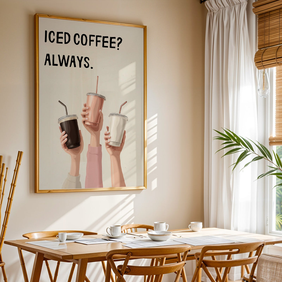 Iced Coffee Always print shown in a gold frame above a breakfast table by a curtained window
