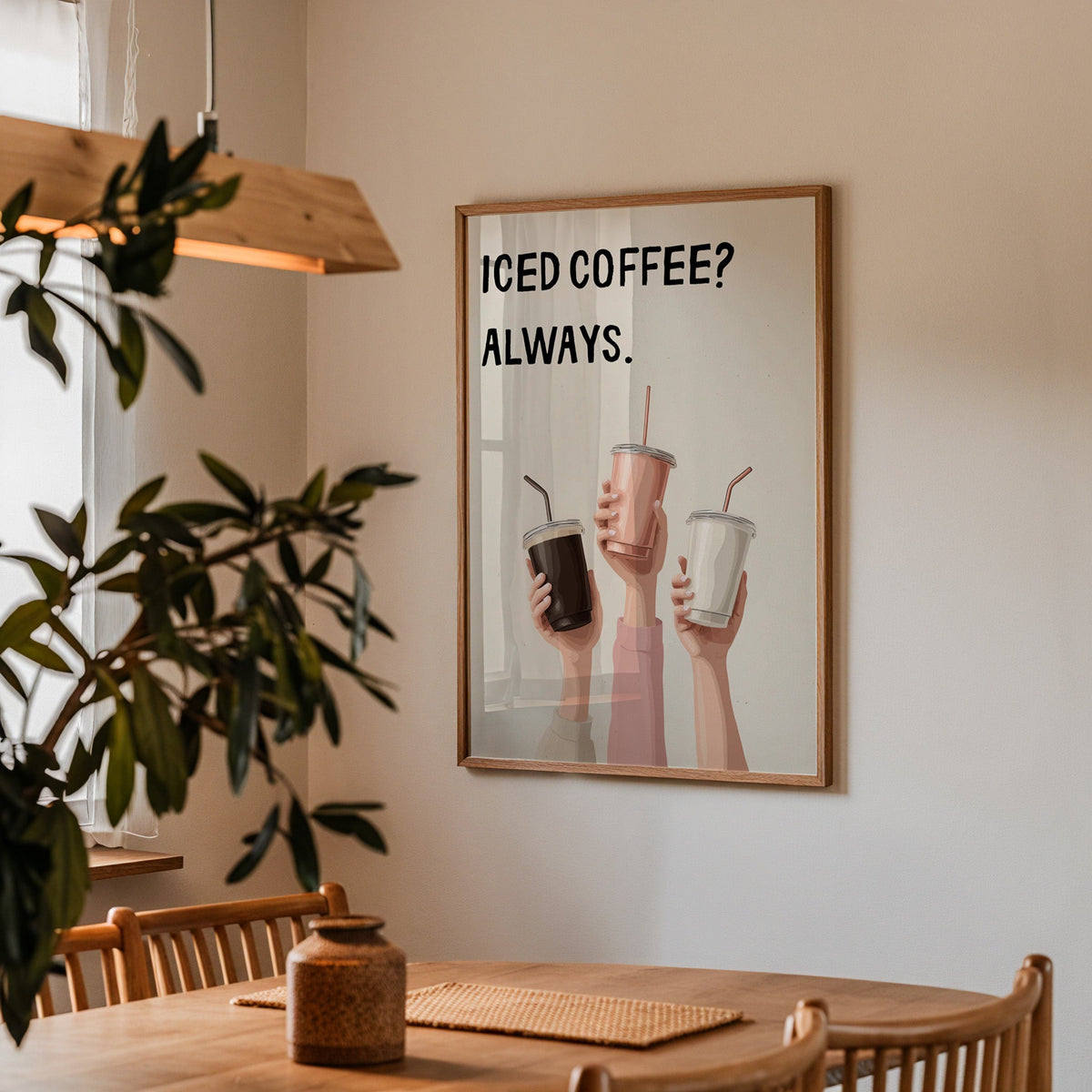 Iced Coffee Always print in a walnut frame above a dining table with olive branches
