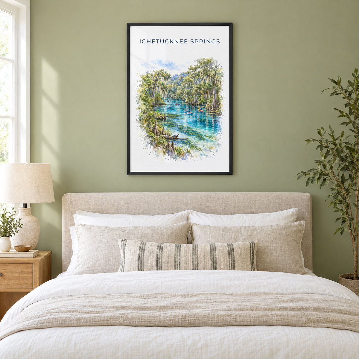 Ichetucknee Springs State Park watercolor print in a black frame above an upholstered headboard in a sage green bedroom