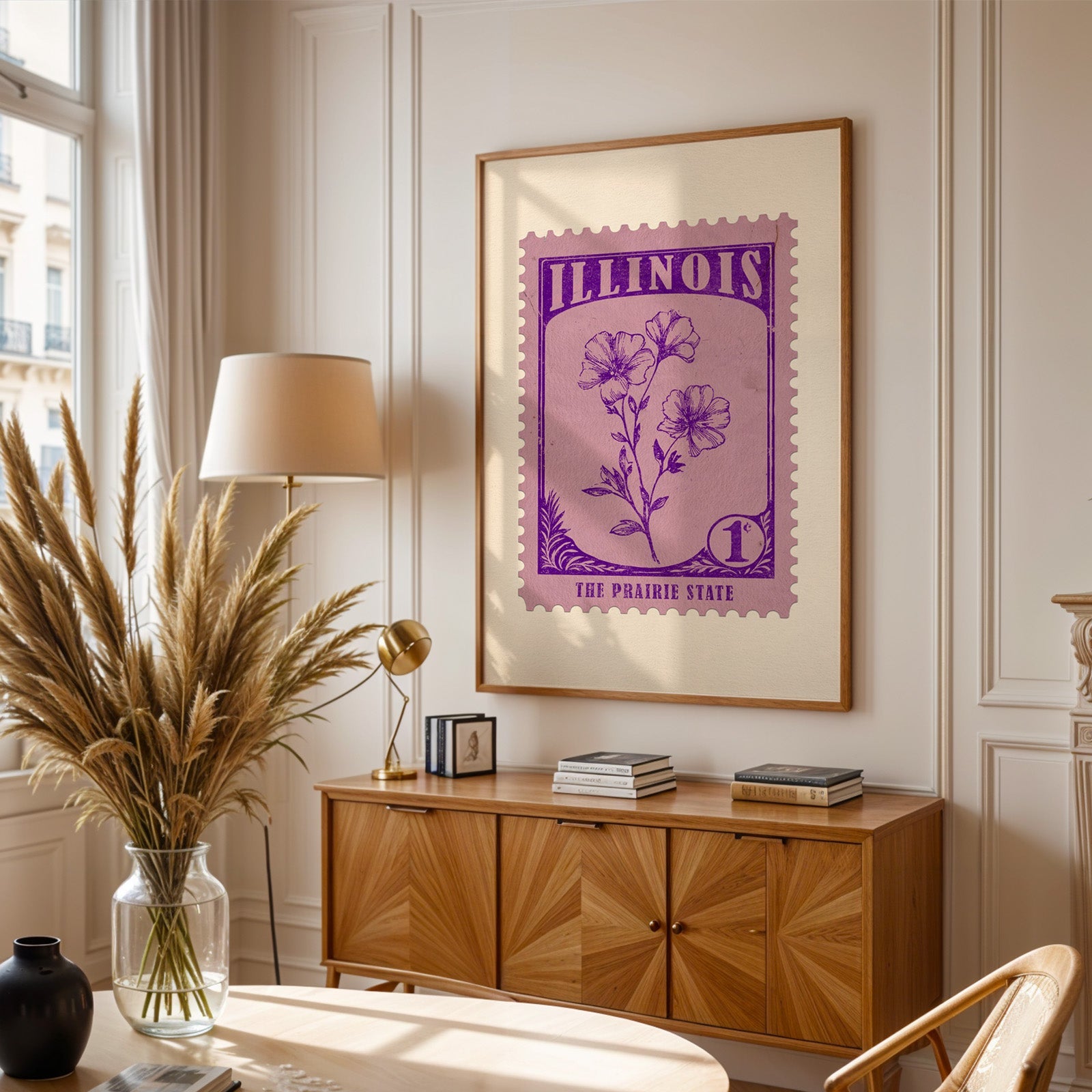 Illinois stamp print framed above a wooden sideboard, pampas grass in a glass vase and a floor lamp