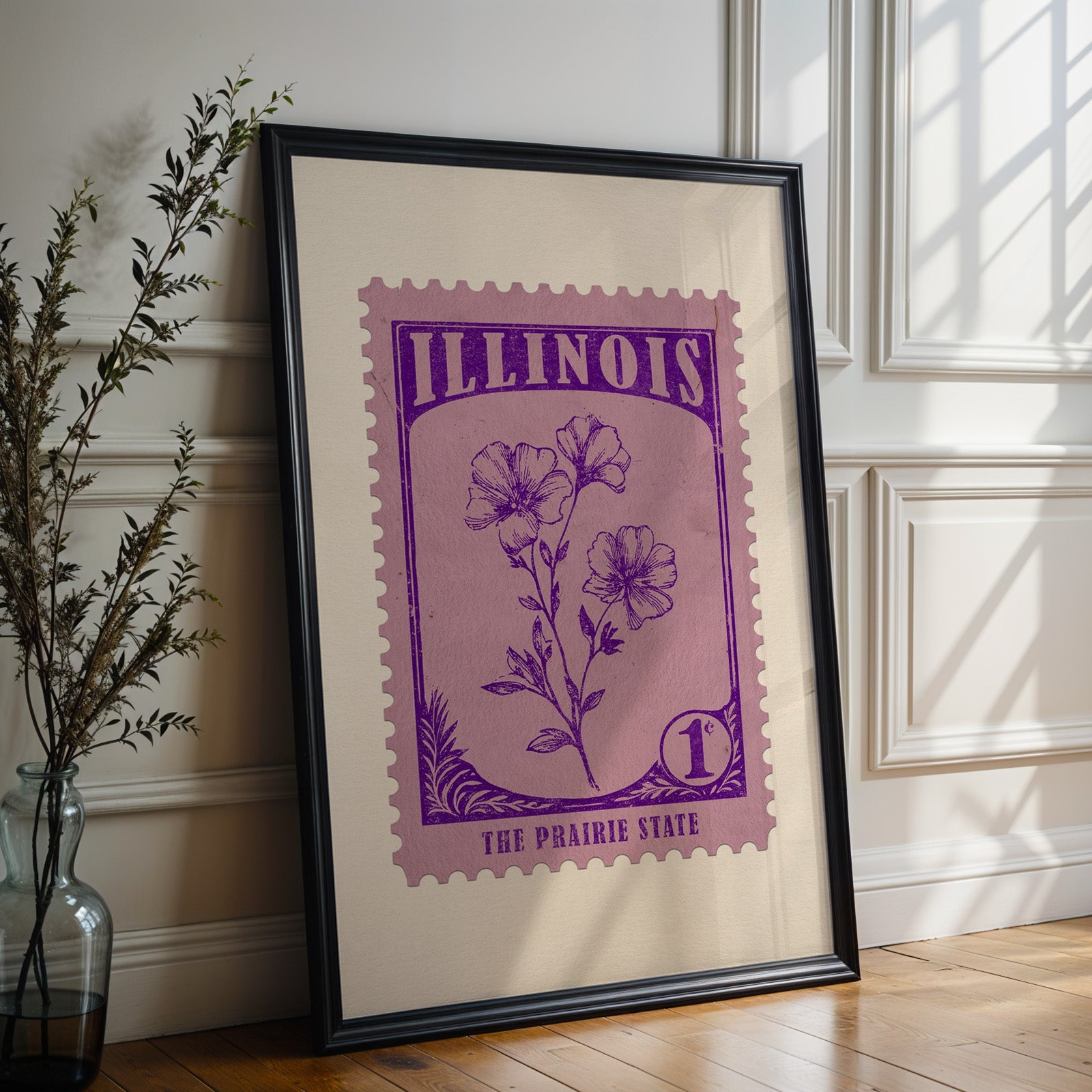 Illinois state flower print in a black frame leaning against a white panelled wall beside olive branches