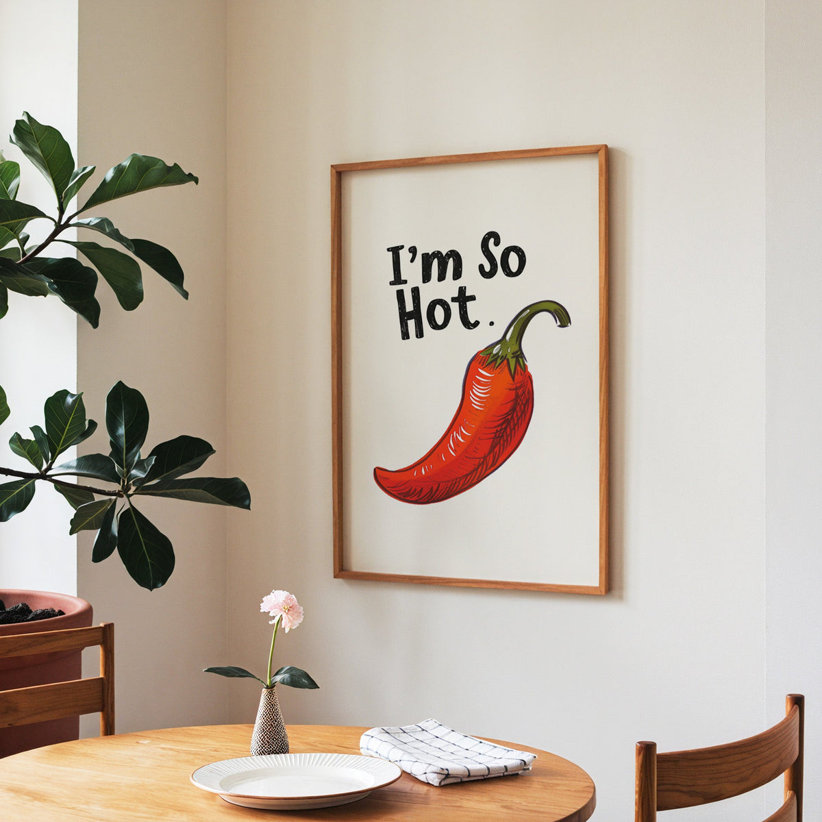I'm So Hot chilli print in a walnut frame above a round table beside a fiddle-leaf fig