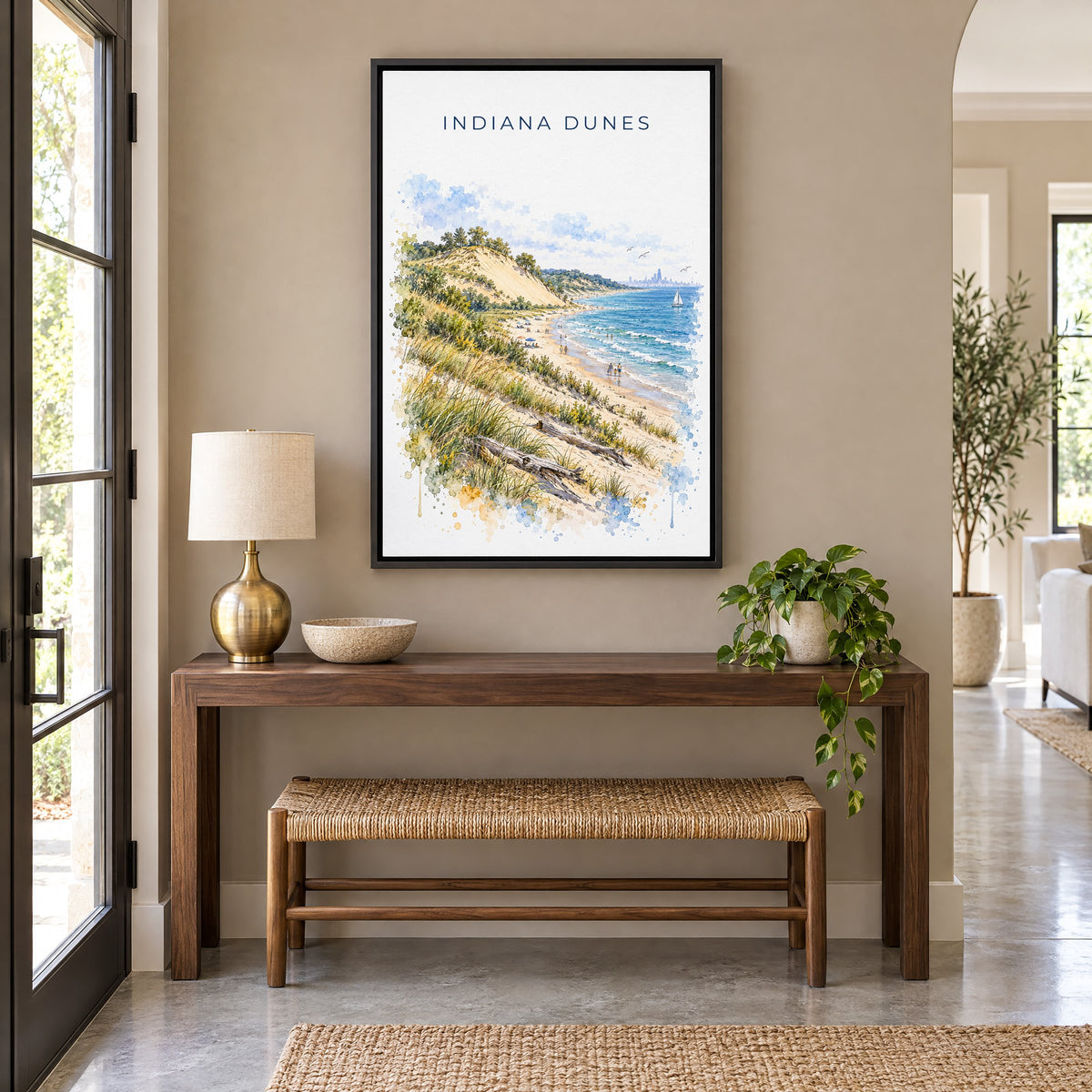 Indiana Dunes National Park watercolor print as a black floater canvas above a walnut console and woven bench in an entryway