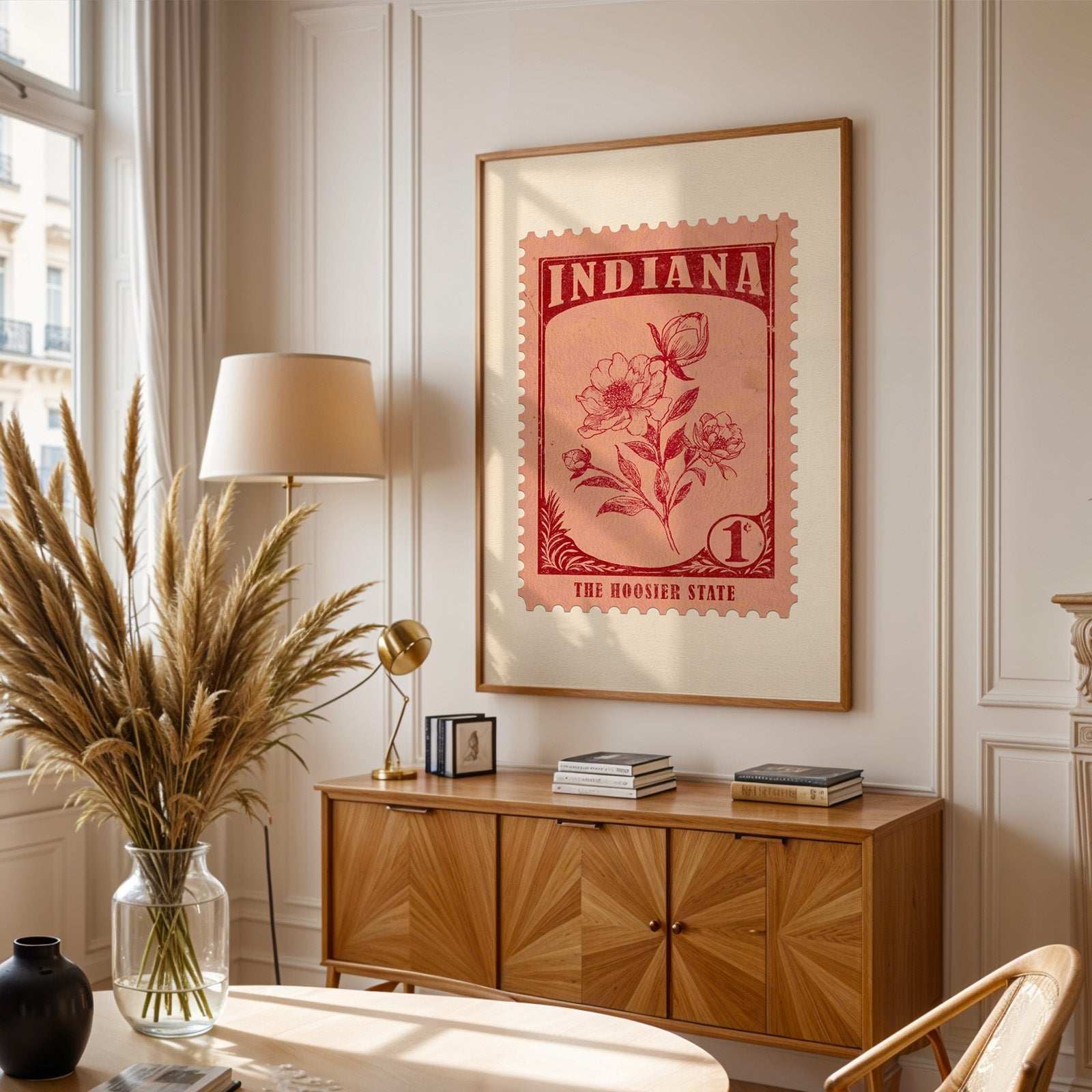 Indiana stamp print framed above a wooden sideboard, pampas grass in a glass vase and a floor lamp