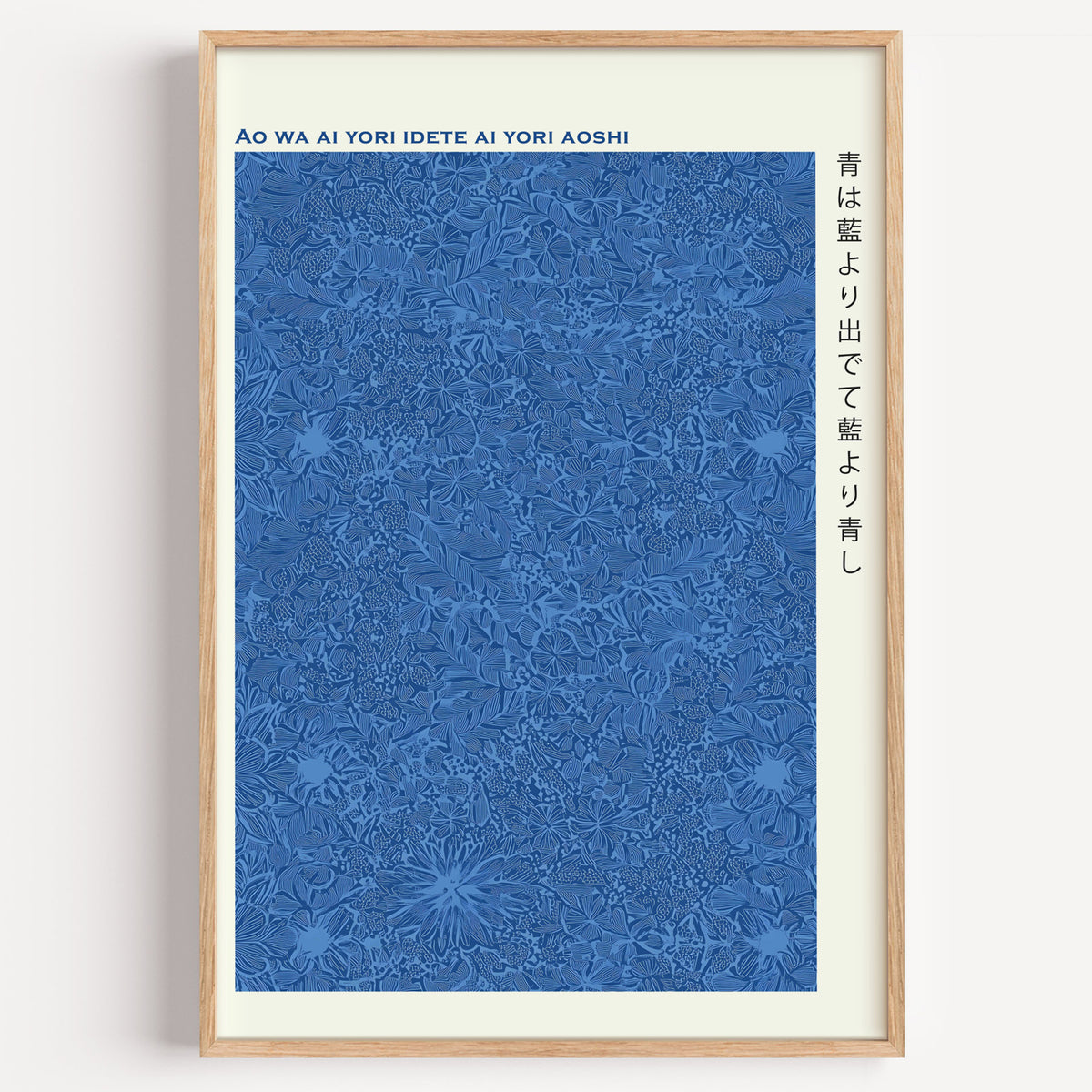 Indigo pattern Japanese proverb print in a light oak frame on a plain white wall