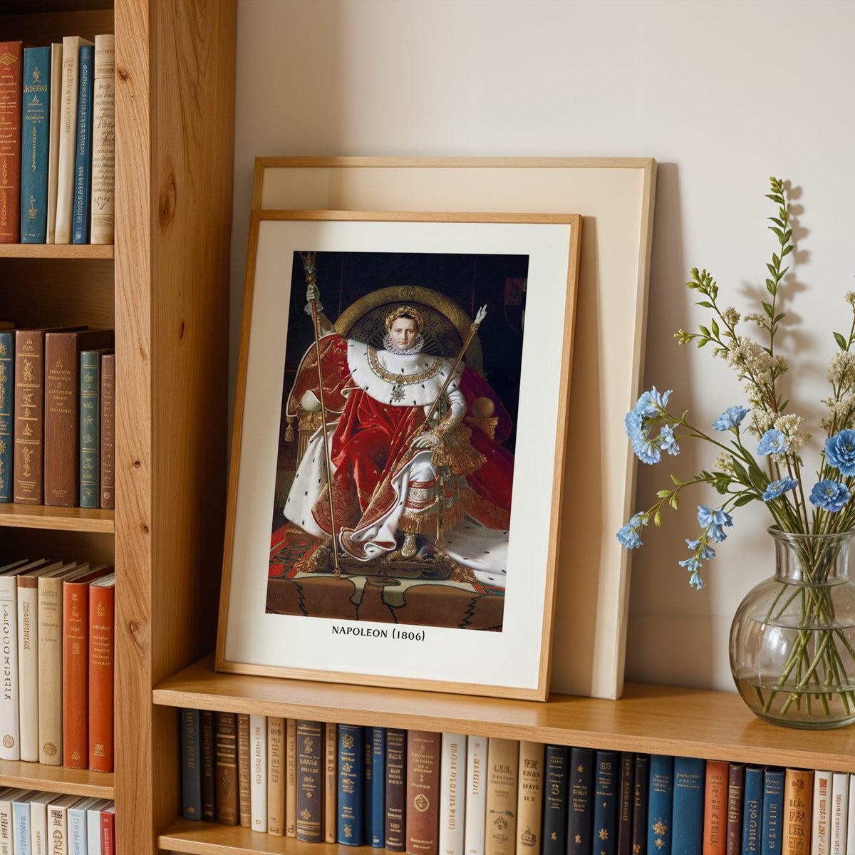 Old masters portrait print in an oak frame leaning on a bookshelf beside flowers