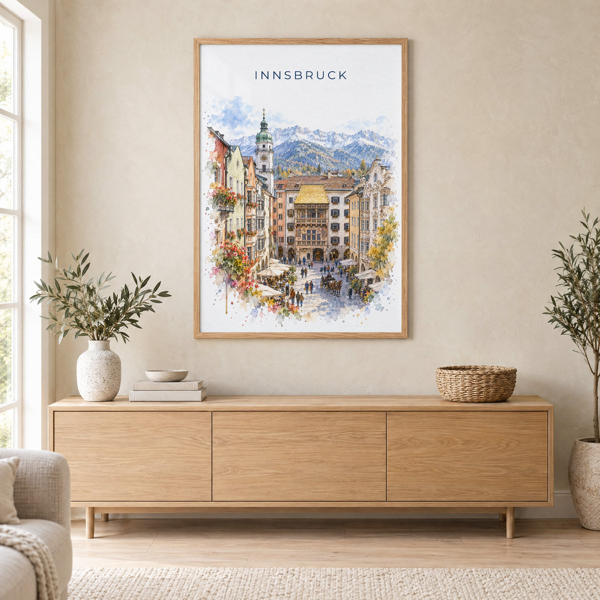 Innsbruck watercolor print in an oak frame above a light wood sideboard in a Scandinavian living room