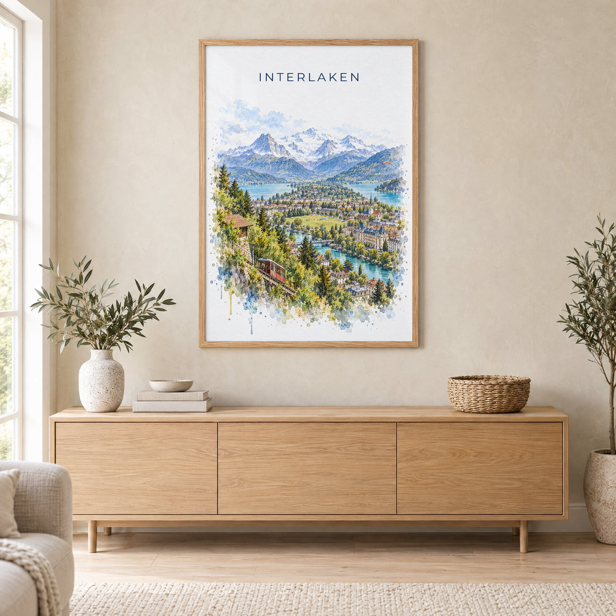 Interlaken watercolor print in an oak frame above a light wood sideboard in a Scandinavian living room
