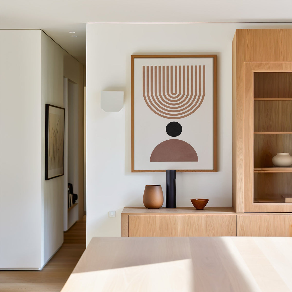 Inverted tan arch and mauve dome mid century print in an oak frame above a light oak sideboard in a dining room