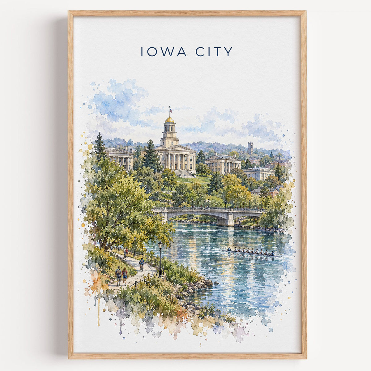 Iowa City watercolor print in a light oak frame on a plain white wall