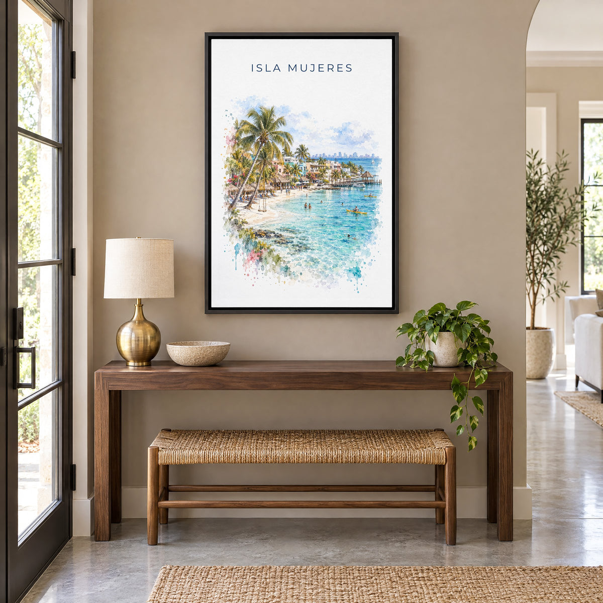 Isla Mujeres watercolor print as a black floater canvas above a walnut console and woven bench in an entryway