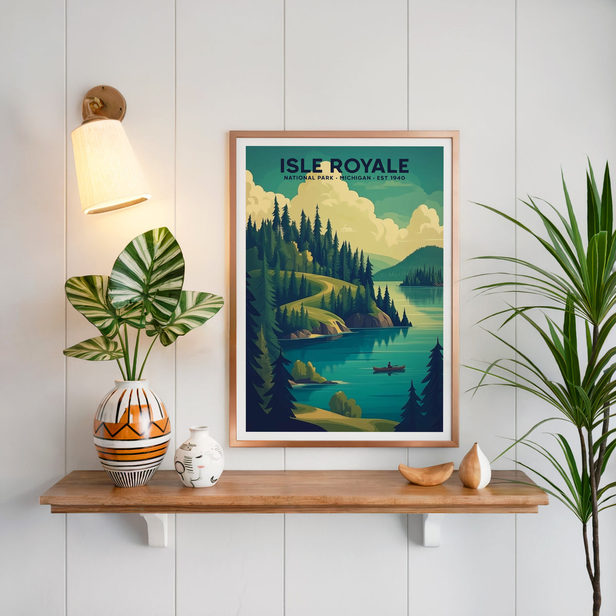 Isle Royale National Park print in a copper frame above an oak shelf on white shiplap with a brass sconce