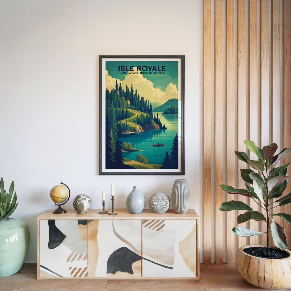 Isle Royale National Park print in a black frame above a light wood sideboard with a globe and ceramic vases