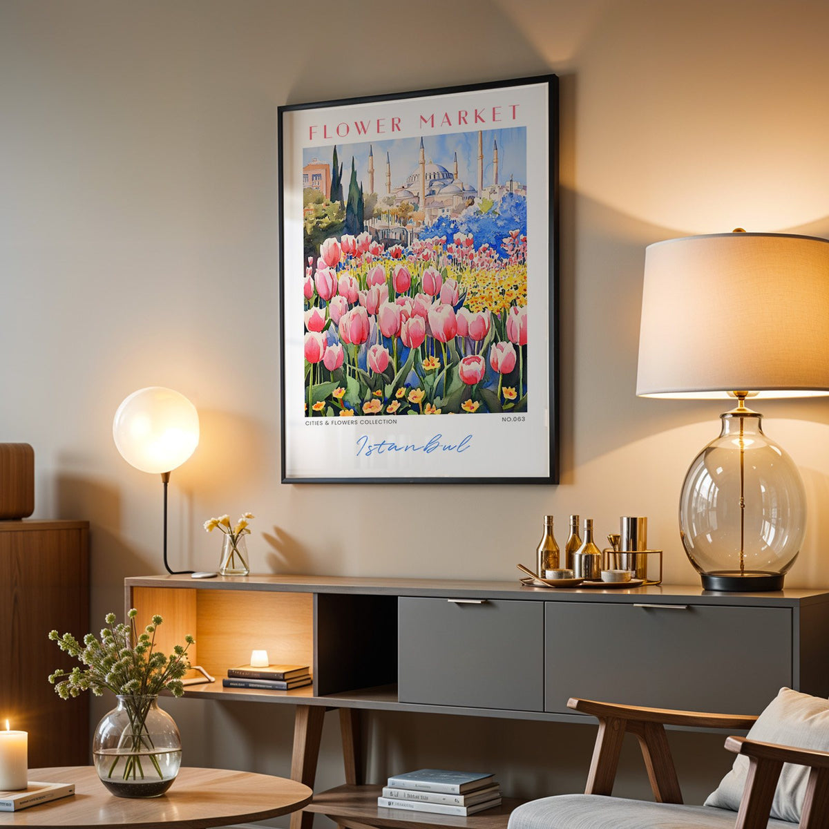 Istanbul flower market print in a black frame above a grey media console with a glass table lamp