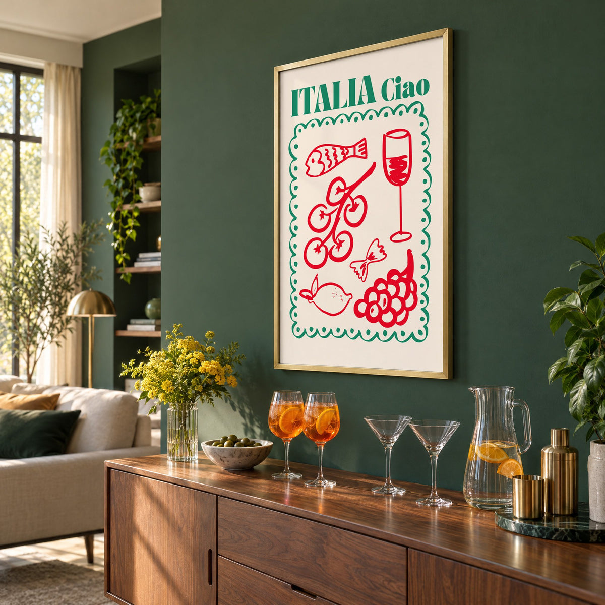 ITALIA Ciao red food doodles print in a brass frame on a bottle green wall above a sideboard with spritz and martini glasses, seen at an angle