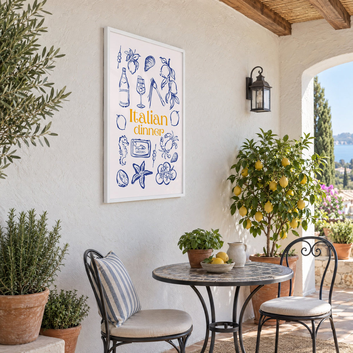 Italian dinner blue doodle print in a white frame on a sunny patio wall beside a potted lemon tree