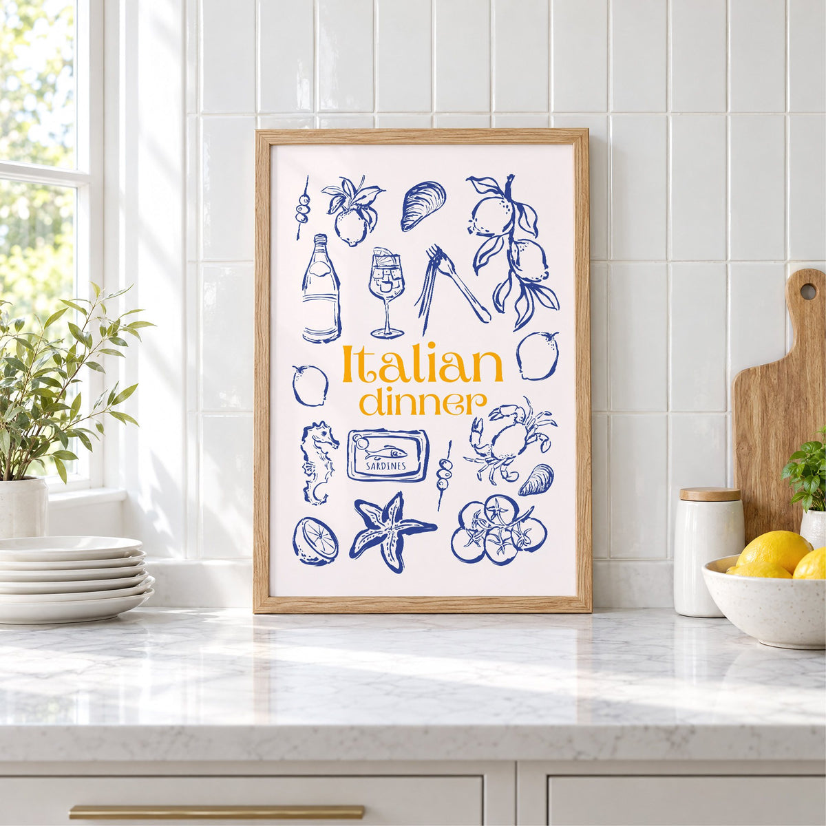 Italian dinner blue doodle print in an oak frame leaning on a marble counter by white tiles and lemons