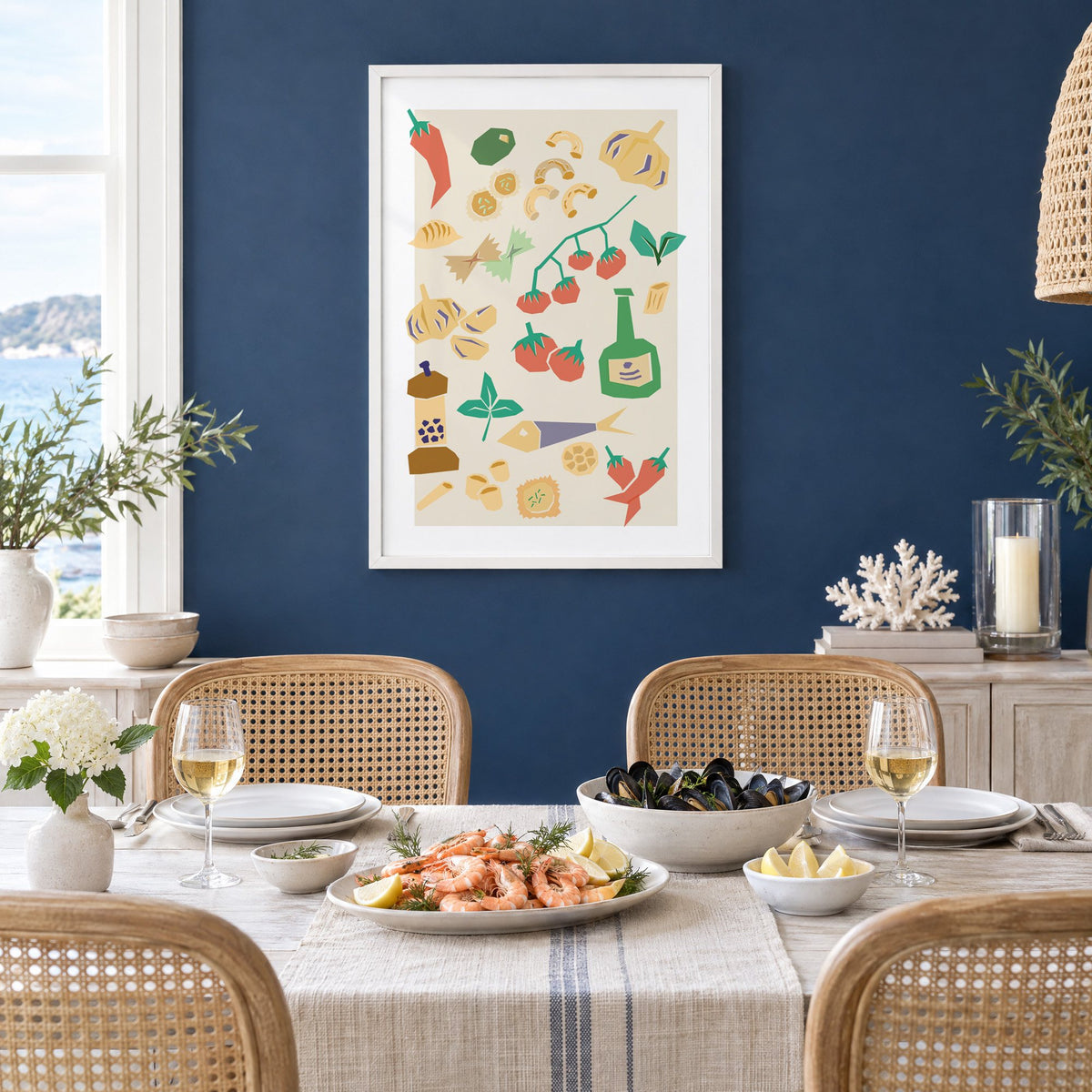 Italian ingredients cut-paper pattern print in a white frame on a navy wall above a dining table set with shrimp and mussels