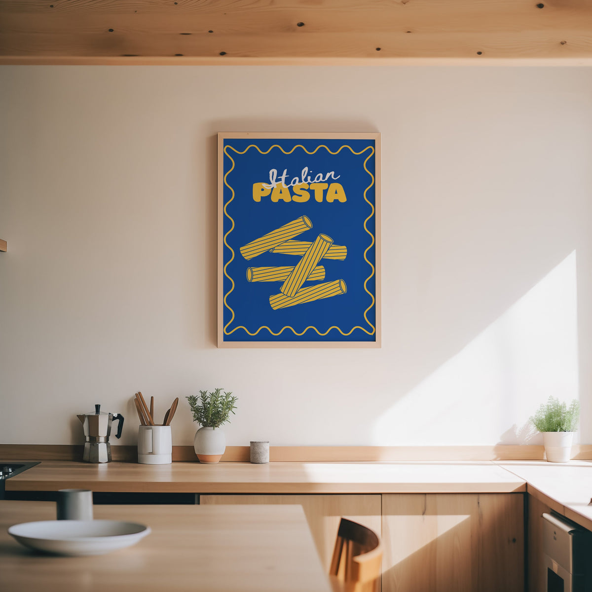 Navy rigatoni print in an oak frame above a wood counter with a moka pot and herbs