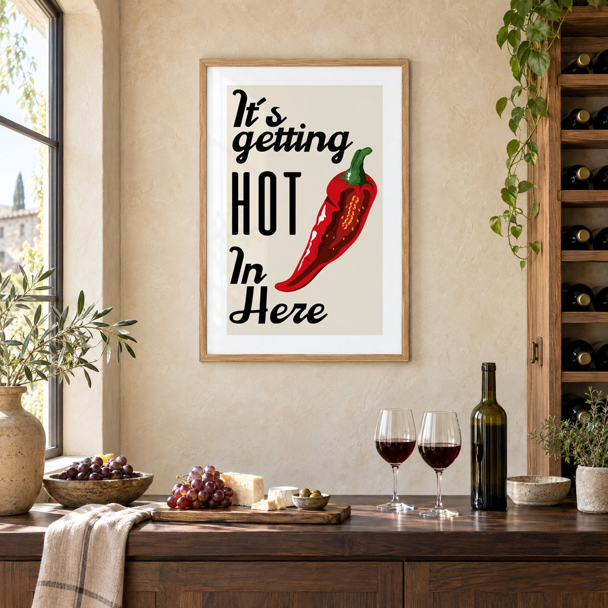 It's getting HOT In Here split chili print in an oak frame on a limewashed wall above a wine counter with red wine, cheese and grapes