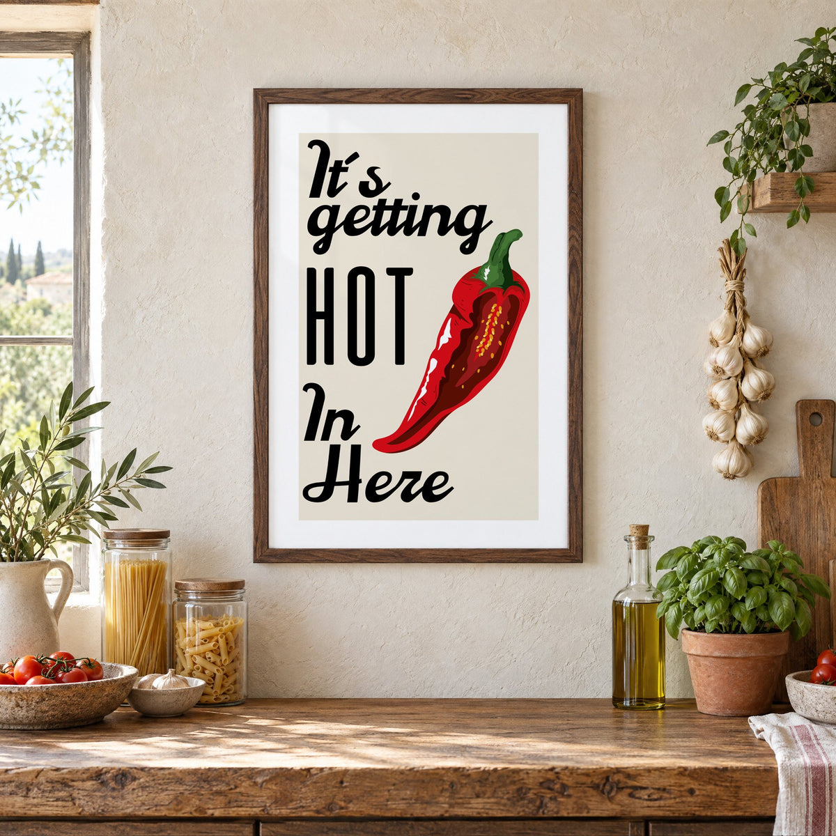 It's getting HOT In Here split chili print in a walnut frame above a rustic Italian pantry counter with pasta jars, garlic and tomatoes