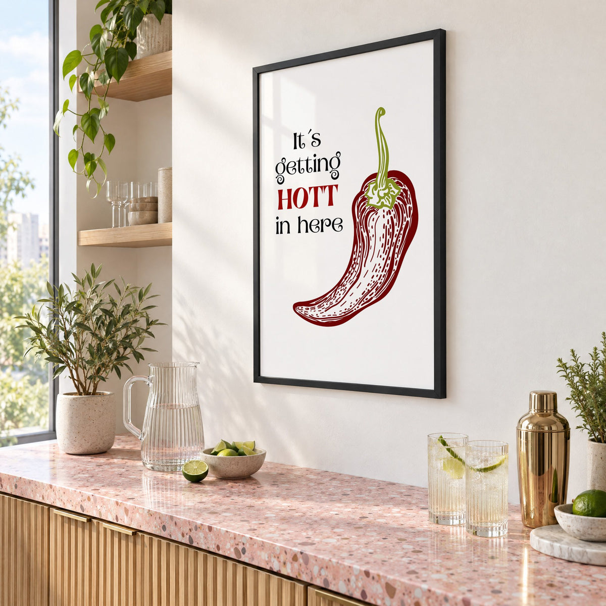 It's getting HOTT red chili print in a black frame above a pink terrazzo cocktail counter with limes, seen at an angle