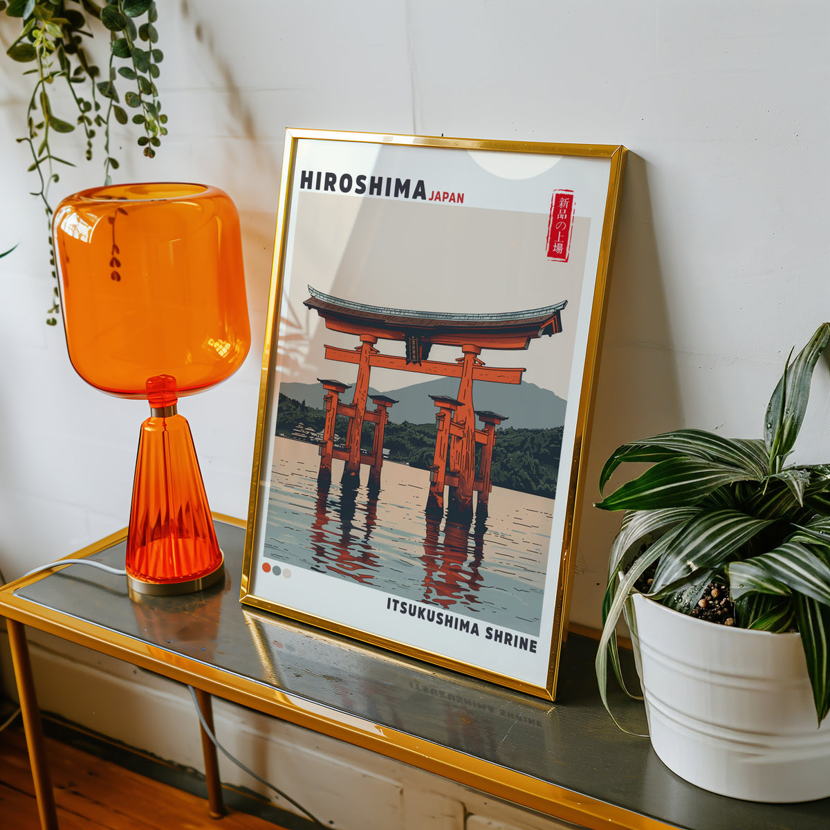 Retro Itsukushima torii gate print shown in a gold frame on a console beside an orange glass lamp
