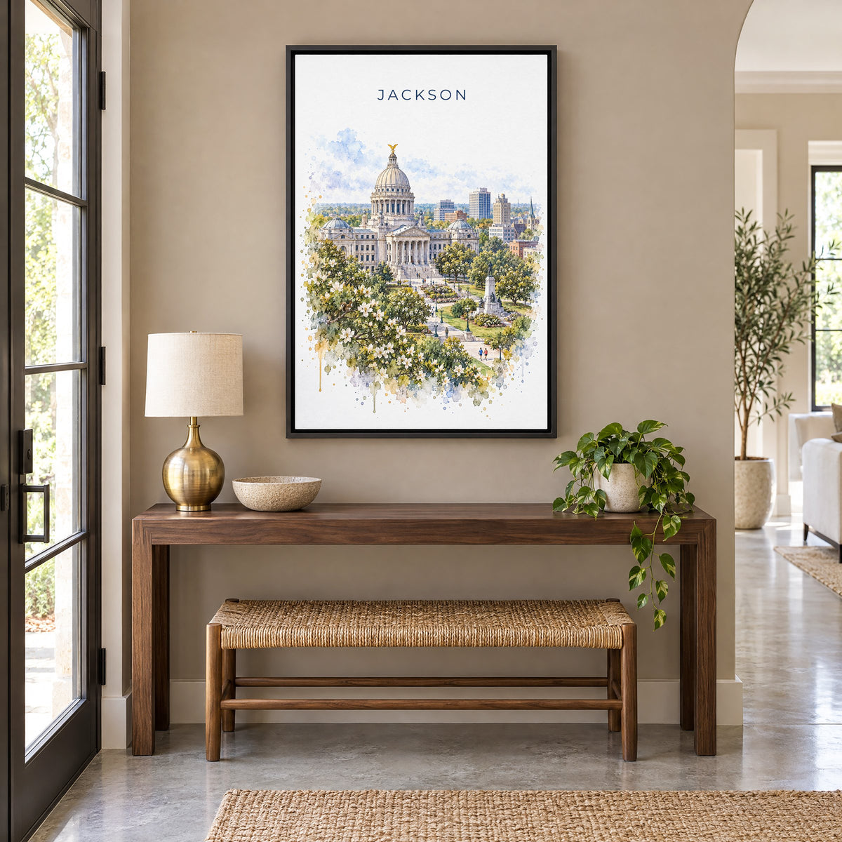 Jackson, Mississippi watercolor print as a black floater canvas above a walnut console and woven bench in an entryway
