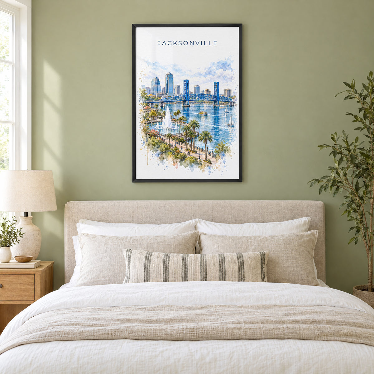 Jacksonville, Florida watercolor print in a black frame above an upholstered headboard in a sage green bedroom