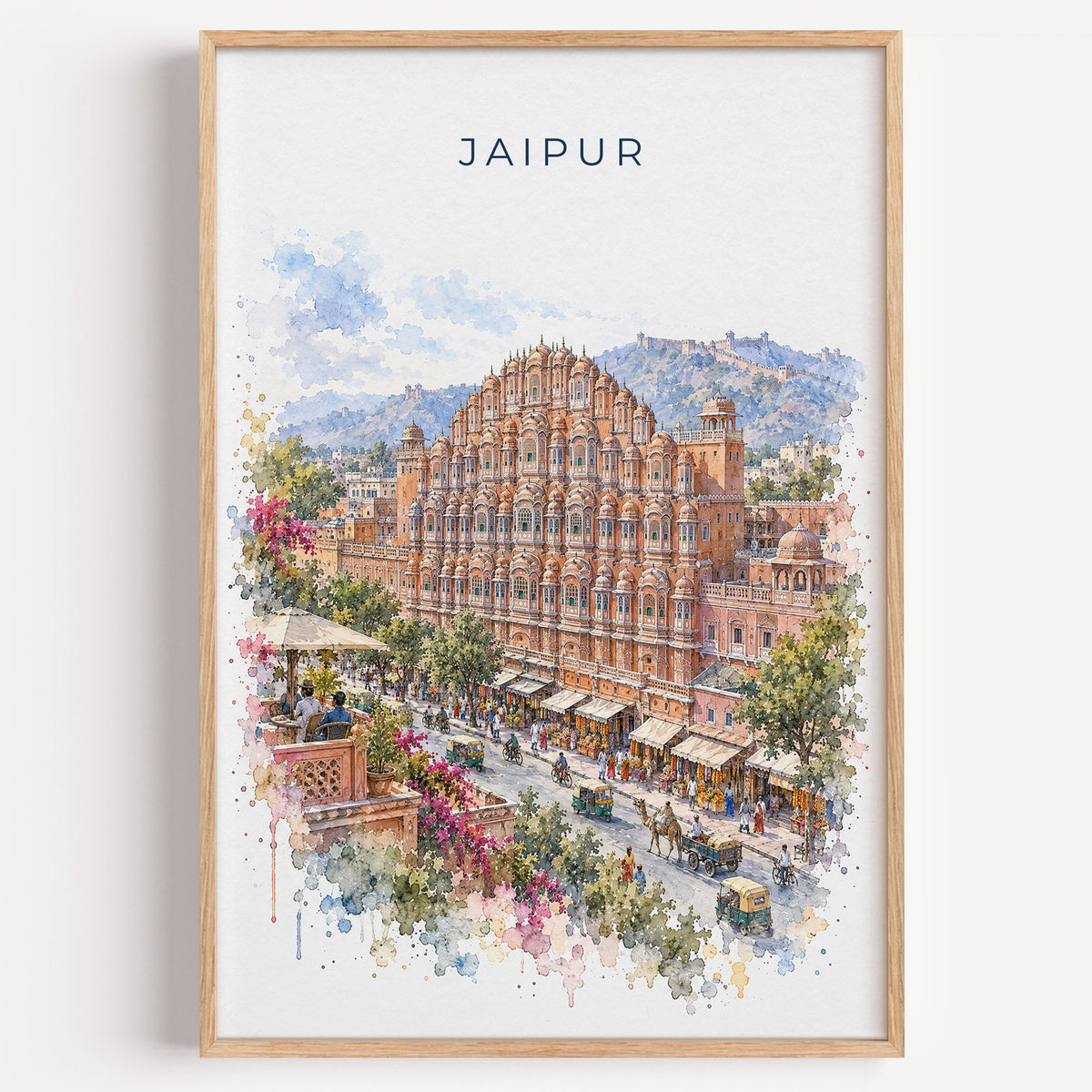 Jaipur watercolor print in a light oak frame on a plain white wall