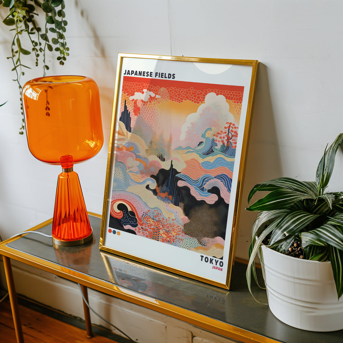 Japanese Fields abstract pattern landscape print shown in a gold frame on a console beside an orange glass lamp