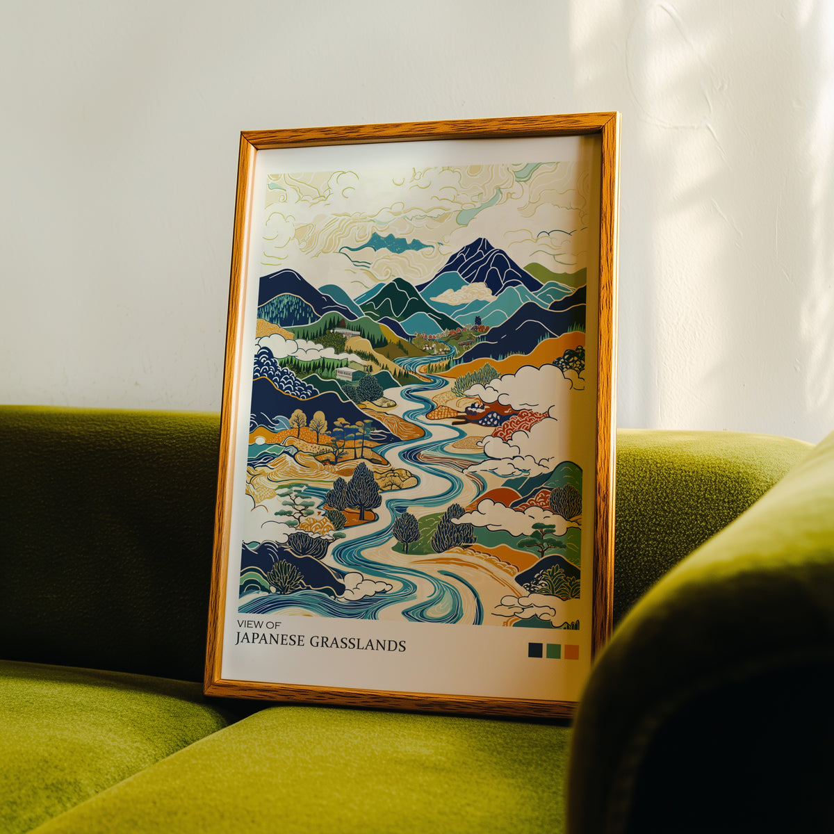 View of Japanese Grasslands river valley print in an oak frame propped on a green velvet sofa