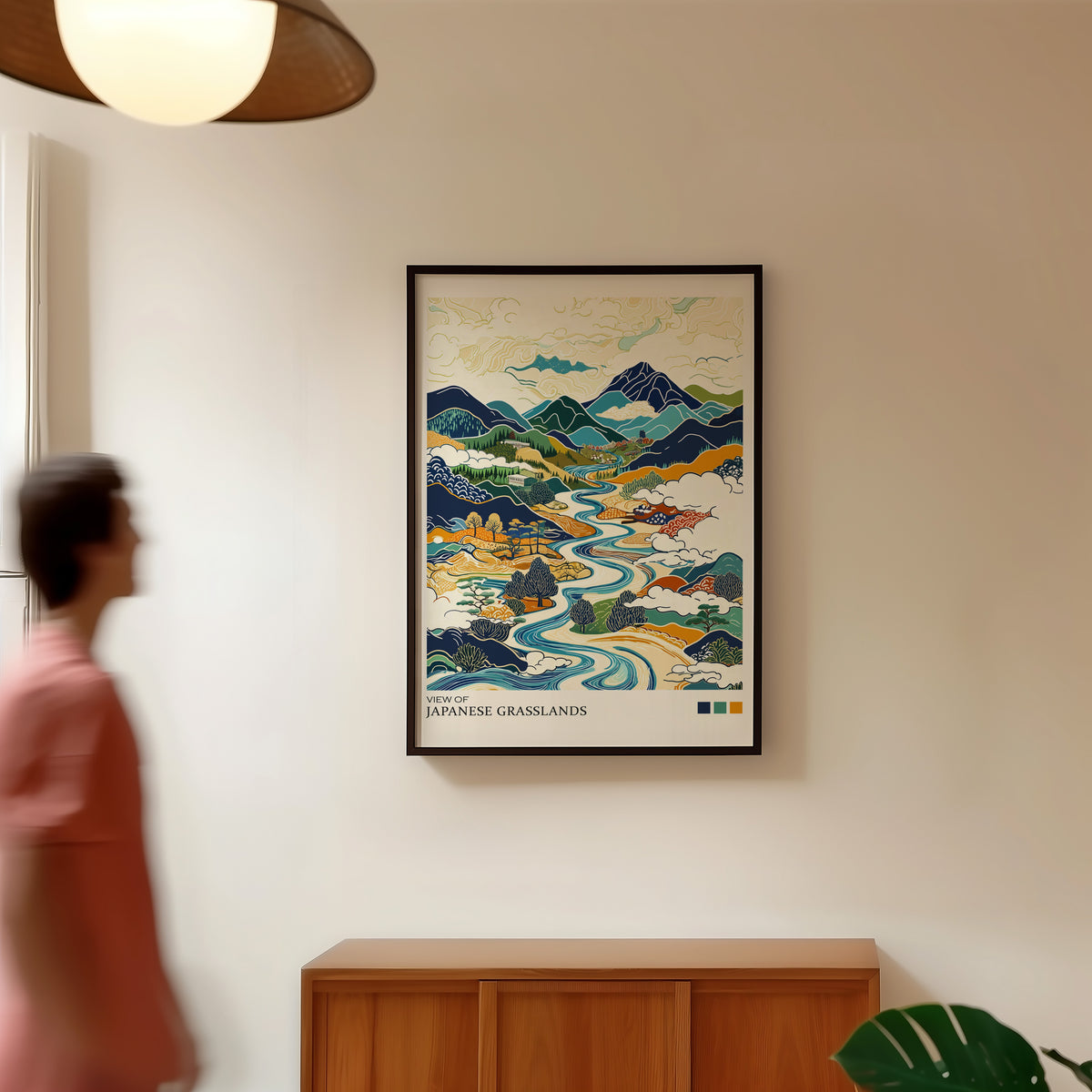 View of Japanese Grasslands river valley print in a black frame in a hallway under a rattan pendant