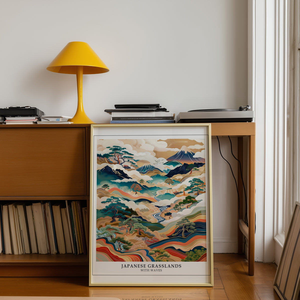 Japanese Grasslands with Waves Fuji print shown in a gold frame below a teak desk with a yellow lamp