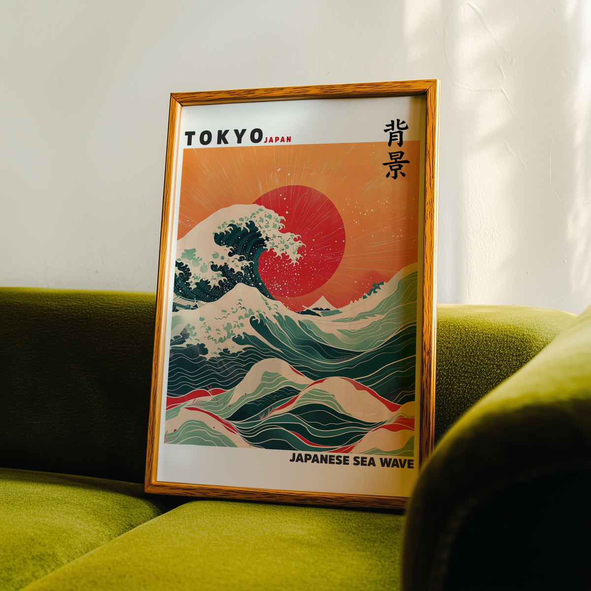 Japanese sea wave red sun print in an oak frame propped on a green velvet sofa