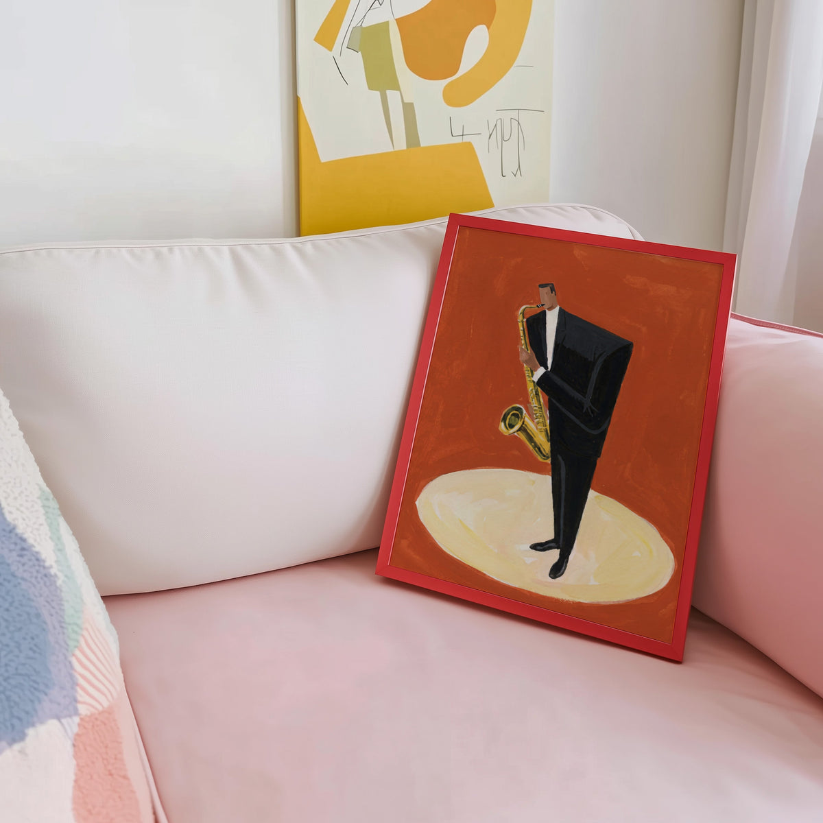 Music wall art print shown in a red frame leaning on a blush pink sofa