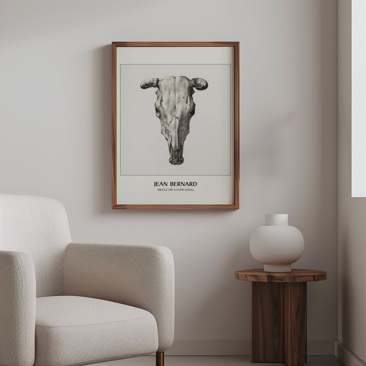 Cow skull drawing in a slim walnut frame above a bouclé armchair