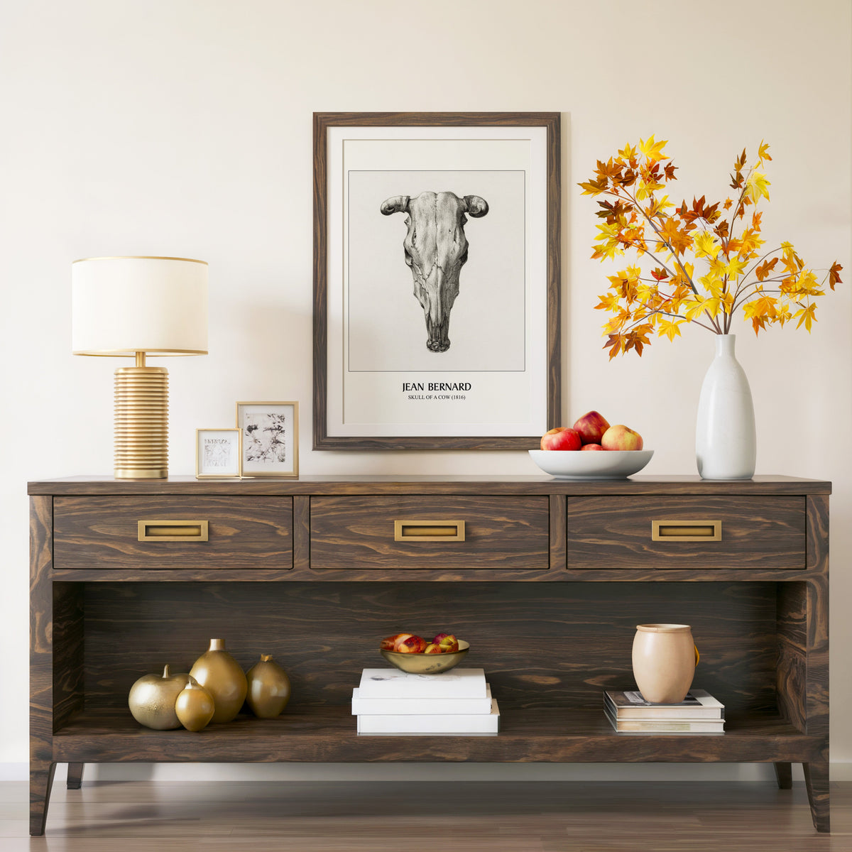 Skull of a Cow print in a walnut frame above a console with autumn branches