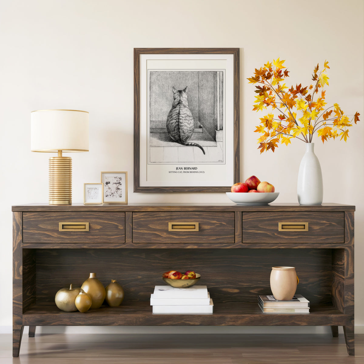 Sitting Cat print in a walnut frame above a console with autumn branches