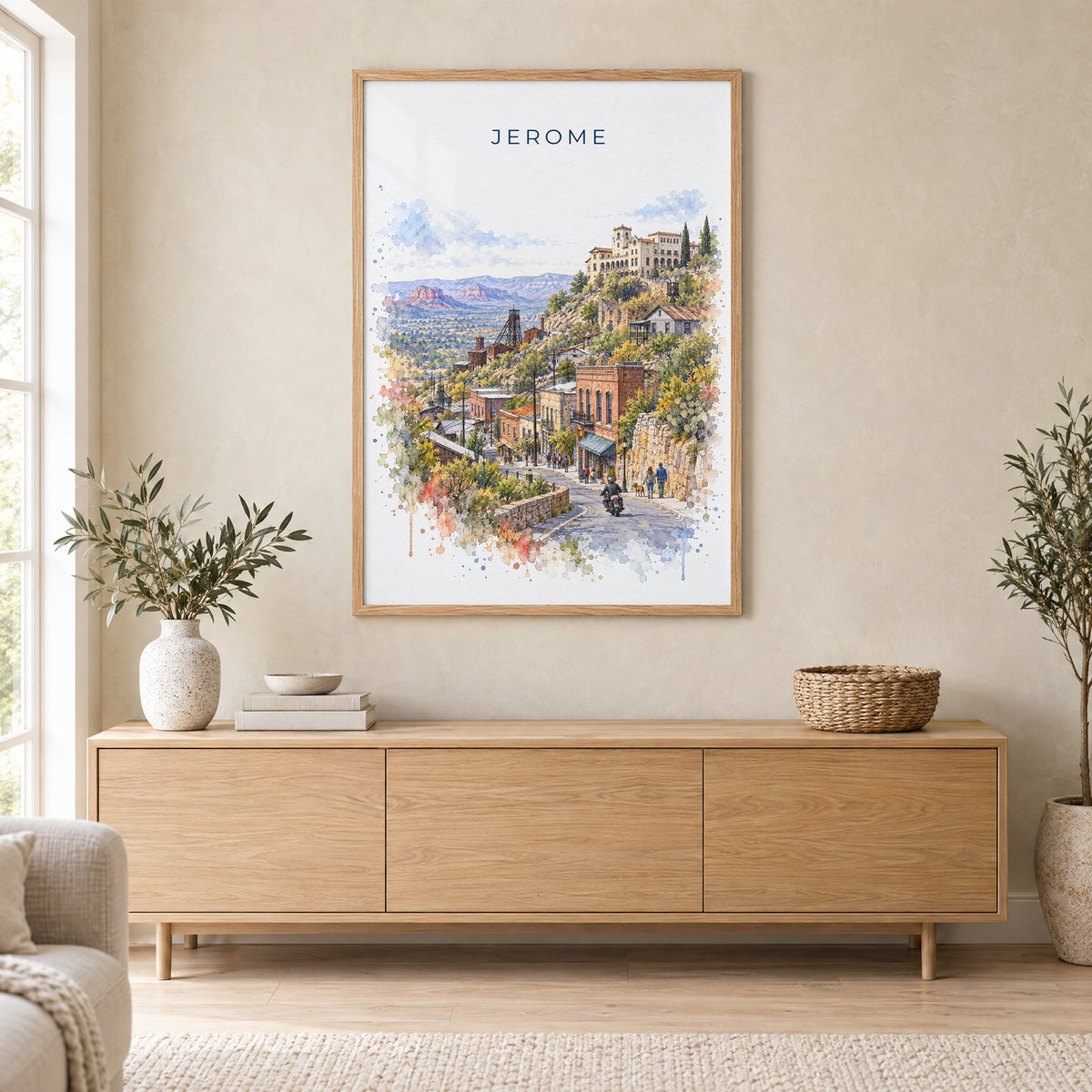 Jerome, Arizona watercolor print in an oak frame above a light wood sideboard in a Scandinavian living room
