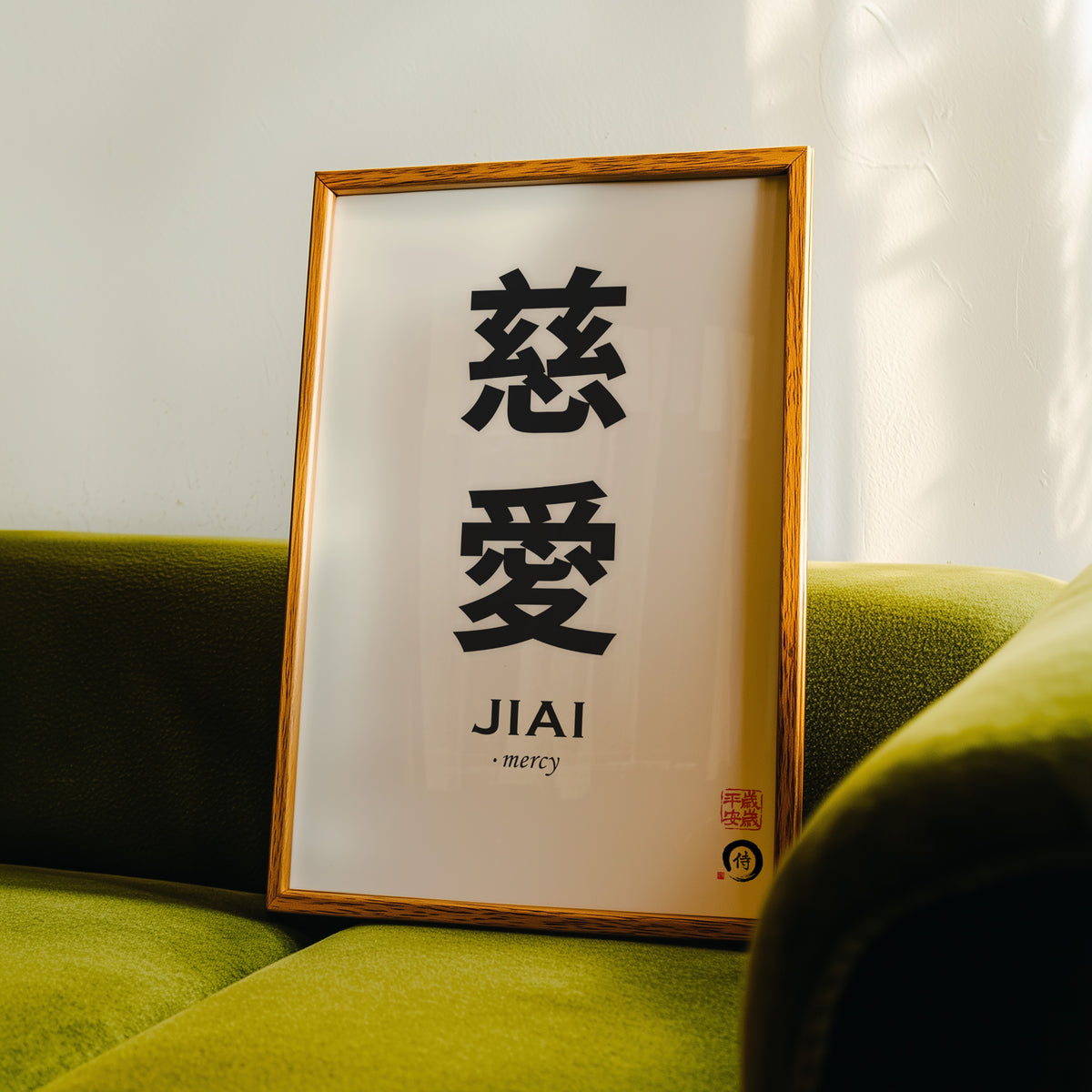 Jiai mercy kanji print in an oak frame propped on a green velvet sofa
