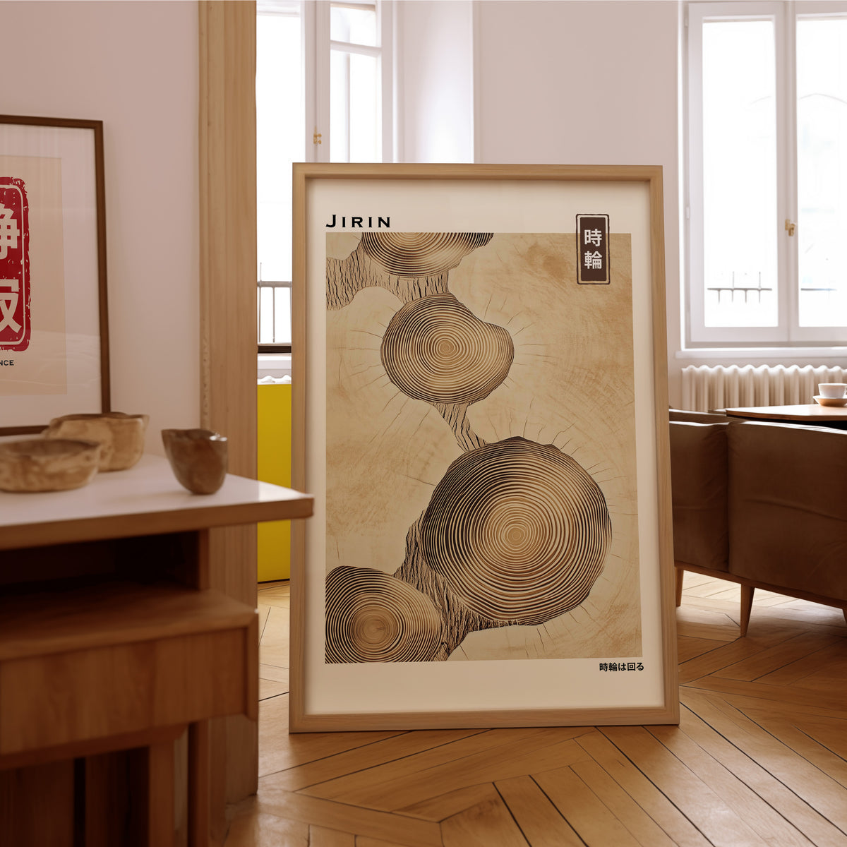 Stacked beige tree ring slices print in an oak frame on the parquet floor of a sunlit living room