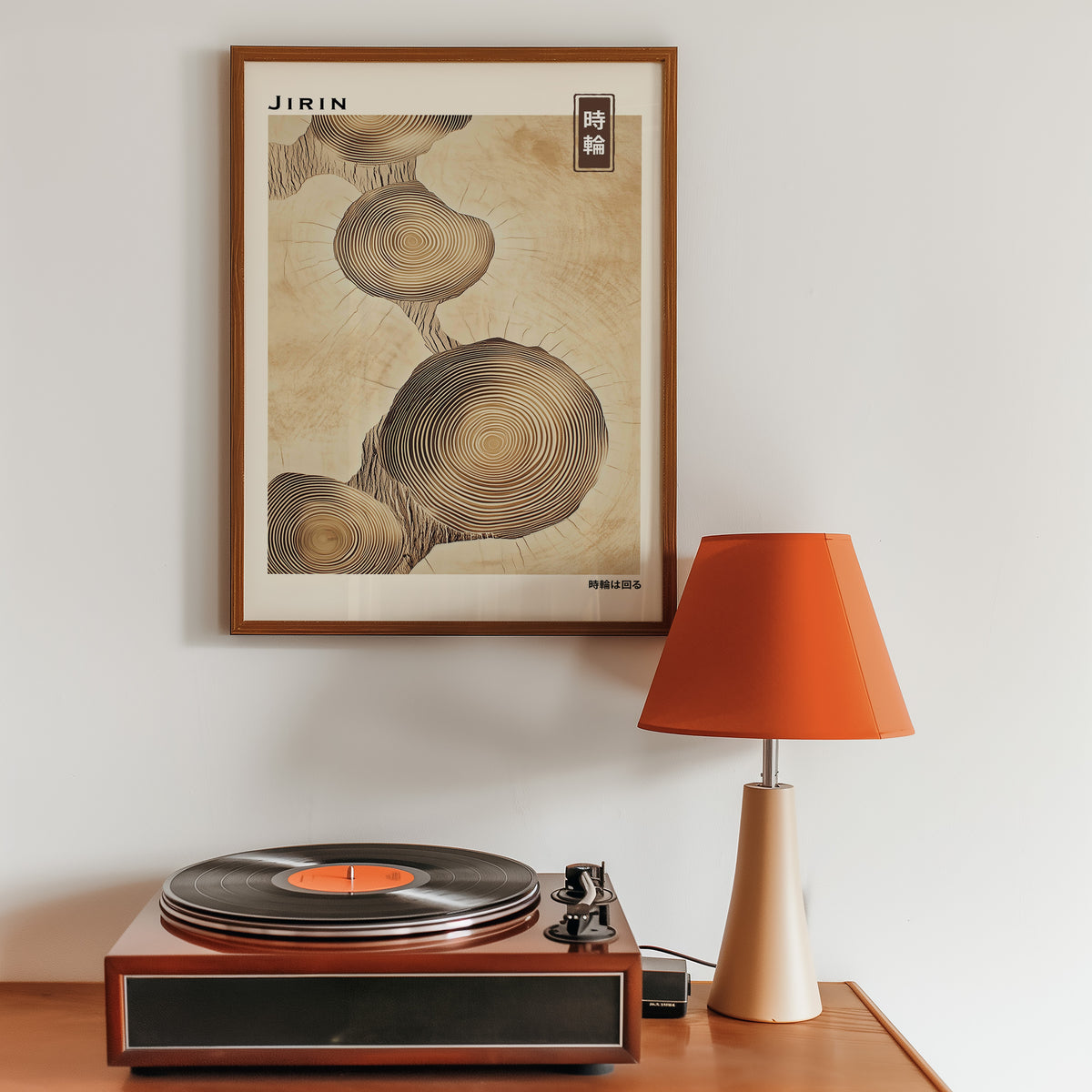 Stacked beige tree ring slices print in a walnut frame above a sideboard with a record player